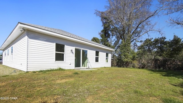 back of property with a yard and fence