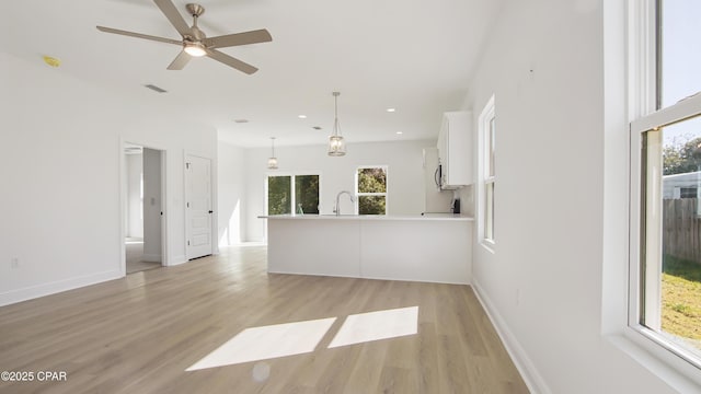 unfurnished living room with a ceiling fan, visible vents, light wood finished floors, recessed lighting, and a sink