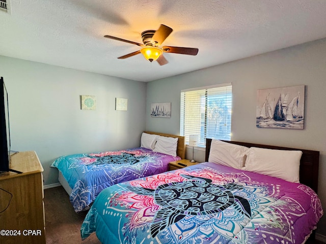 carpeted bedroom with a textured ceiling and ceiling fan