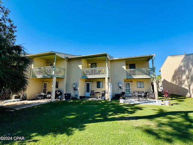 back of property with a patio, a balcony, and a yard