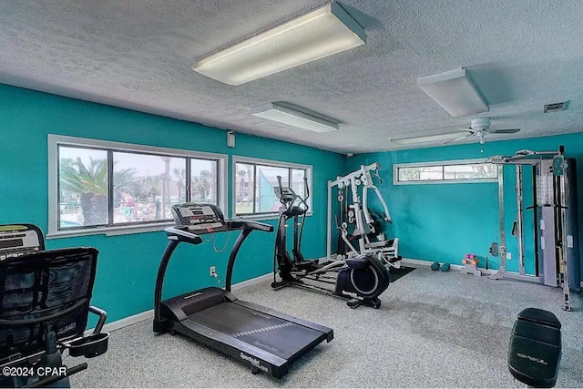 workout area featuring a textured ceiling and ceiling fan