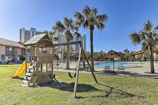 view of play area with a community pool and a yard