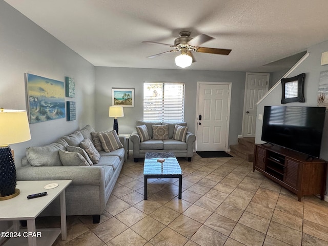 living room with a textured ceiling and ceiling fan