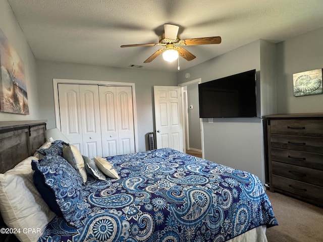 bedroom featuring a textured ceiling, carpet floors, a closet, and ceiling fan