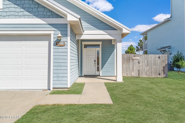 property entrance featuring a yard and a garage