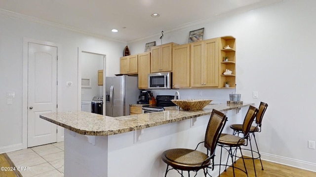 kitchen featuring stainless steel appliances, light tile patterned flooring, a breakfast bar, light stone counters, and kitchen peninsula