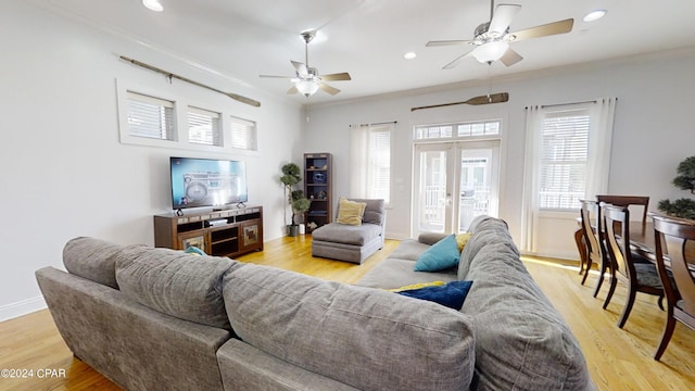 living room with plenty of natural light, ceiling fan, ornamental molding, and light hardwood / wood-style flooring