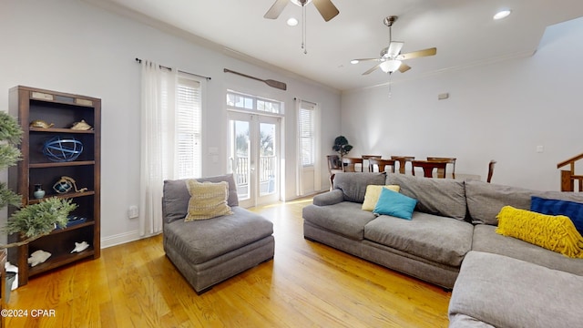 living room with light wood-type flooring, ceiling fan, and crown molding