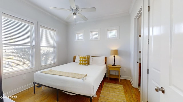 bedroom featuring ornamental molding, light wood-type flooring, and ceiling fan