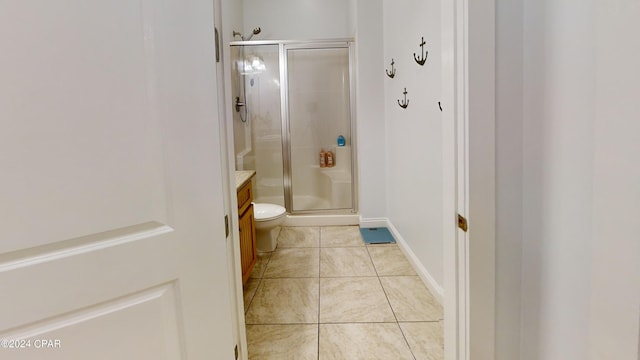 bathroom featuring vanity, tile patterned flooring, toilet, and an enclosed shower