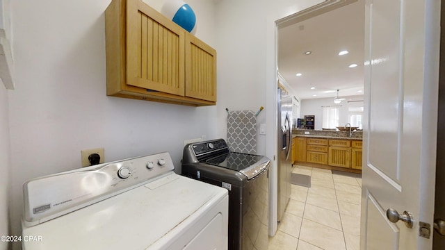 laundry room featuring sink, cabinets, independent washer and dryer, and light tile patterned floors