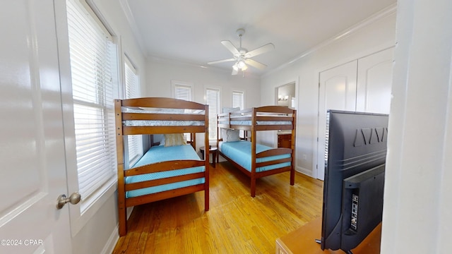 bedroom featuring ceiling fan, light wood-type flooring, and crown molding