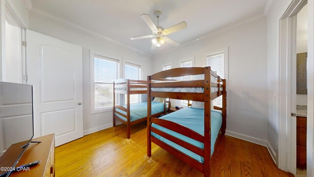 bedroom featuring hardwood / wood-style floors, ceiling fan, and crown molding