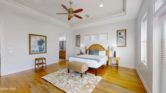 bedroom featuring light wood-type flooring, multiple windows, and connected bathroom