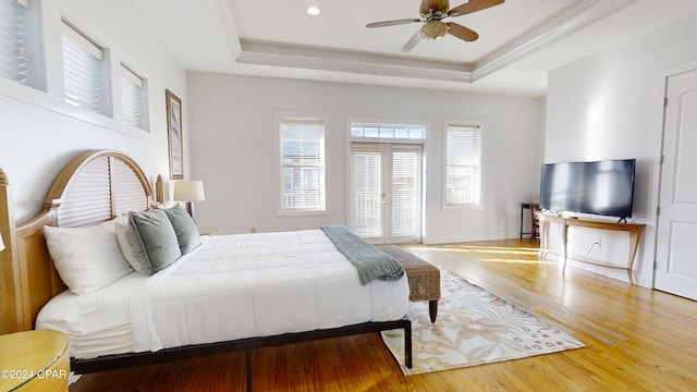 bedroom featuring wood-type flooring, ceiling fan, and a tray ceiling