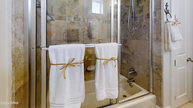 bathroom featuring combined bath / shower with glass door