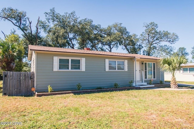 view of front of property featuring a front lawn and fence