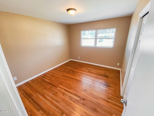 unfurnished bedroom with a closet, baseboards, and light wood finished floors