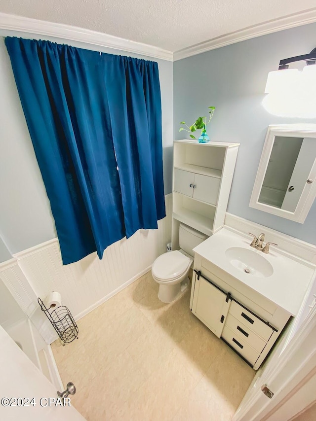 bathroom featuring toilet, crown molding, vanity, and a textured ceiling