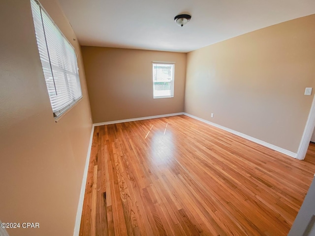 empty room with light wood-style floors and baseboards