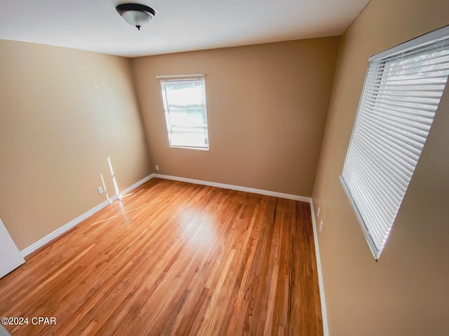 unfurnished room with light wood-style flooring and baseboards