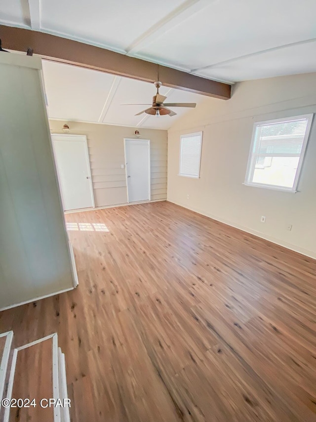 spare room with vaulted ceiling with beams, ceiling fan, and wood finished floors