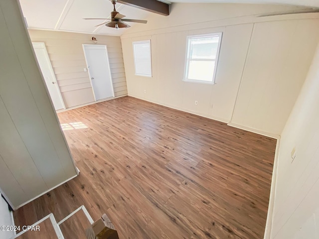 unfurnished room with hardwood / wood-style flooring, wooden walls, lofted ceiling with beams, and ceiling fan