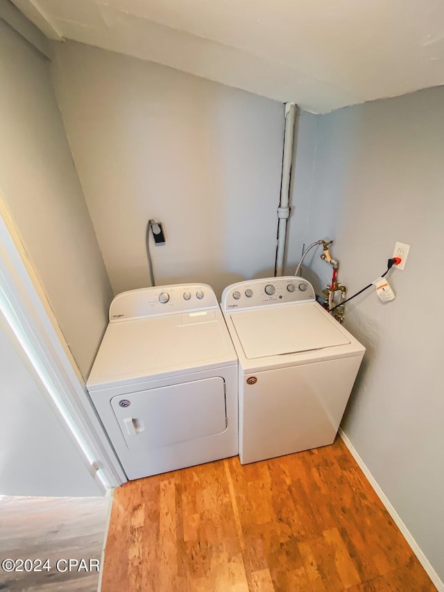 laundry area with light wood finished floors, laundry area, baseboards, and separate washer and dryer