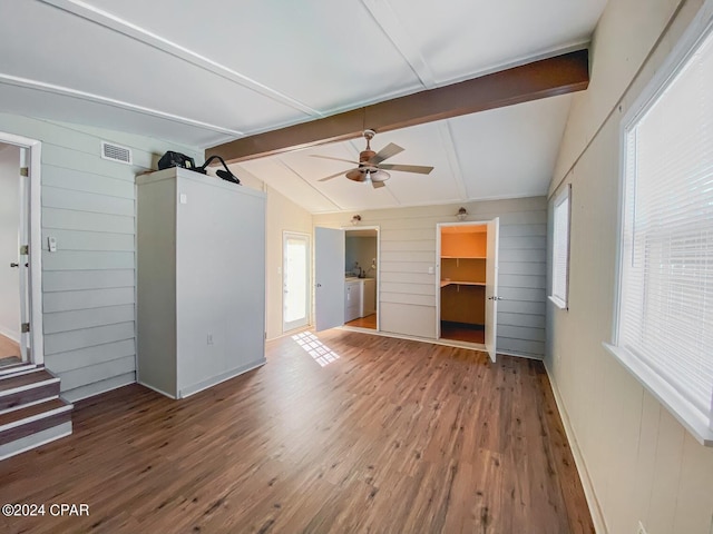 unfurnished living room with wood finished floors, visible vents, a ceiling fan, lofted ceiling with beams, and washer and dryer