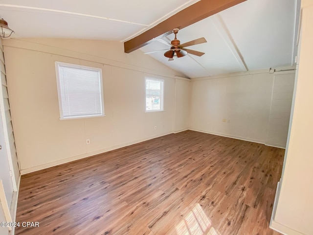 unfurnished room with ceiling fan, wood finished floors, and vaulted ceiling with beams