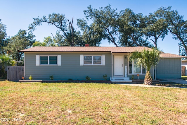 ranch-style home featuring a chimney, a front lawn, and fence