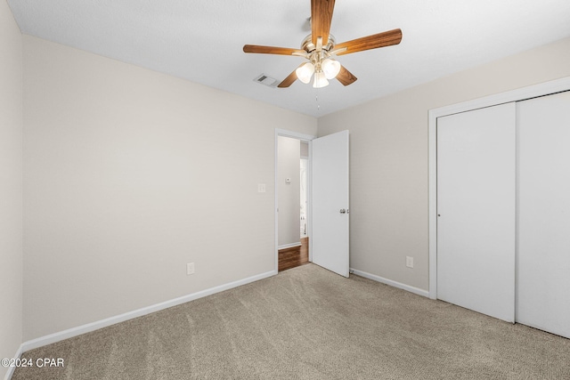 unfurnished bedroom with carpet floors, a closet, and ceiling fan