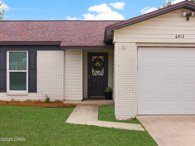 single story home with a garage and a front lawn