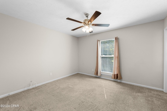 carpeted spare room with ceiling fan and a textured ceiling