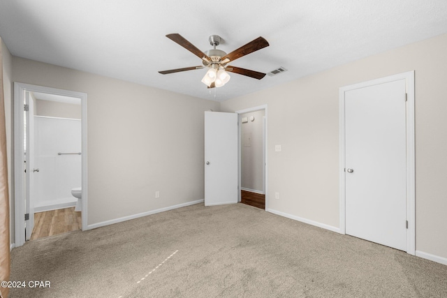 unfurnished bedroom featuring ceiling fan, carpet, and connected bathroom