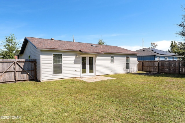 back of property featuring a lawn and french doors