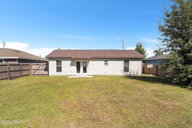 rear view of house featuring french doors and a yard