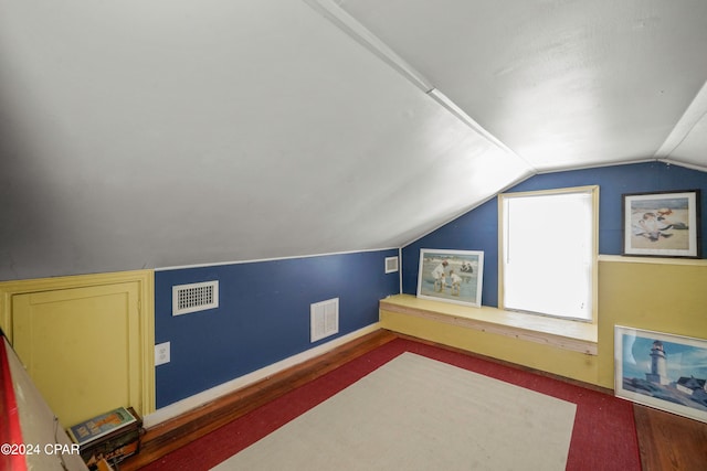 bonus room featuring dark carpet and lofted ceiling