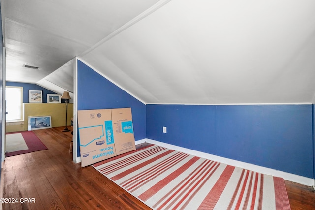 bonus room with dark hardwood / wood-style flooring and vaulted ceiling