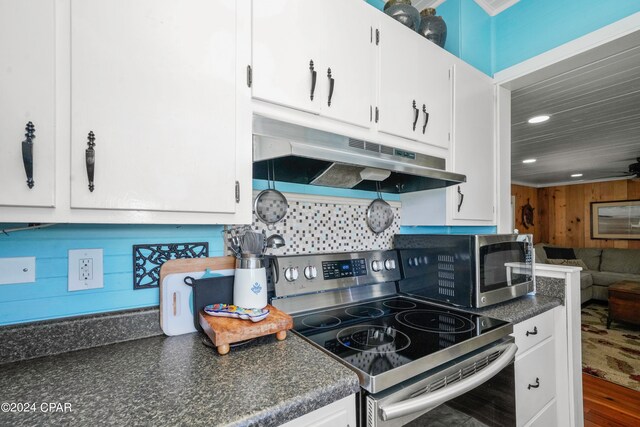 kitchen with white cabinetry, wood-type flooring, stainless steel electric range oven, and tasteful backsplash