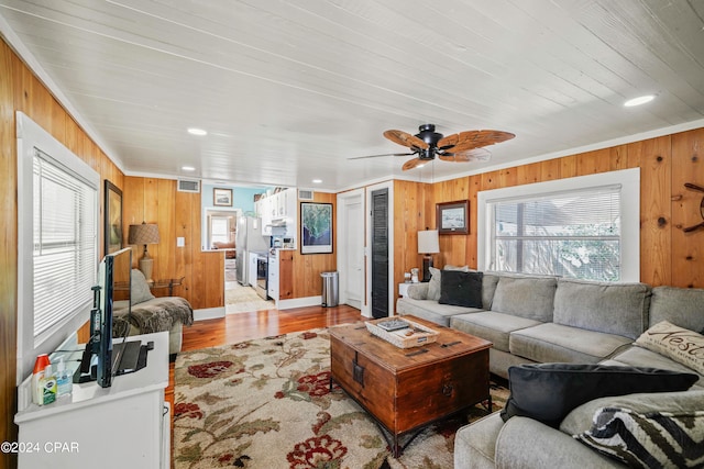 living room with light hardwood / wood-style floors and wooden walls