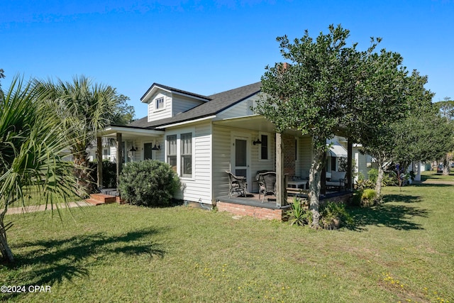 back of house featuring covered porch and a yard