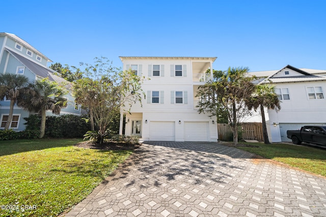 view of property featuring a garage, a front lawn, and a balcony