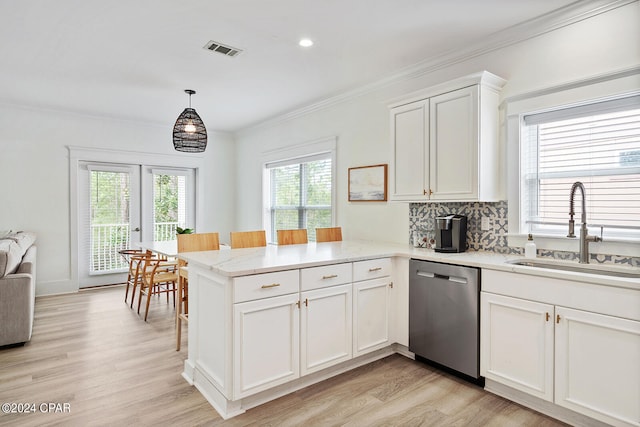 kitchen with a healthy amount of sunlight, kitchen peninsula, stainless steel dishwasher, and sink