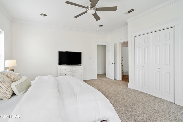 bedroom with light colored carpet, ceiling fan, crown molding, and a closet