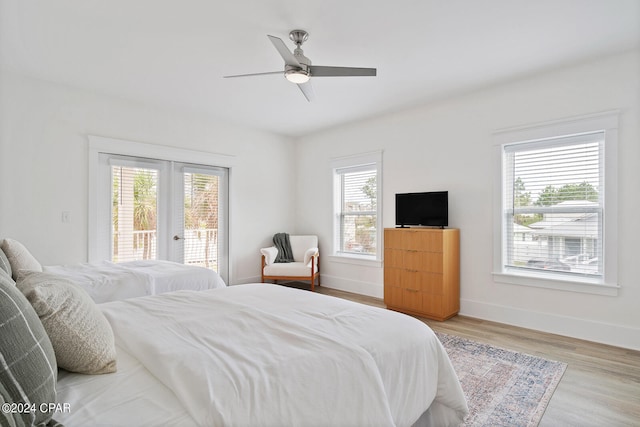 bedroom featuring light hardwood / wood-style floors, multiple windows, and access to outside