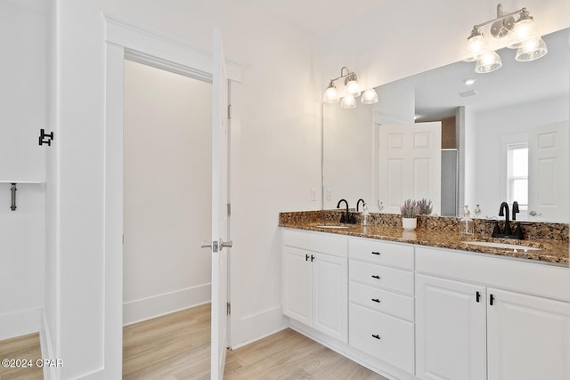 bathroom with hardwood / wood-style floors, vanity, and an enclosed shower