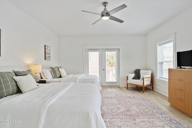 bedroom with light hardwood / wood-style floors, ceiling fan, multiple windows, and access to outside