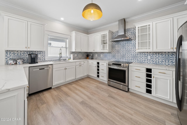 kitchen featuring stainless steel appliances, sink, wall chimney range hood, light hardwood / wood-style flooring, and decorative light fixtures