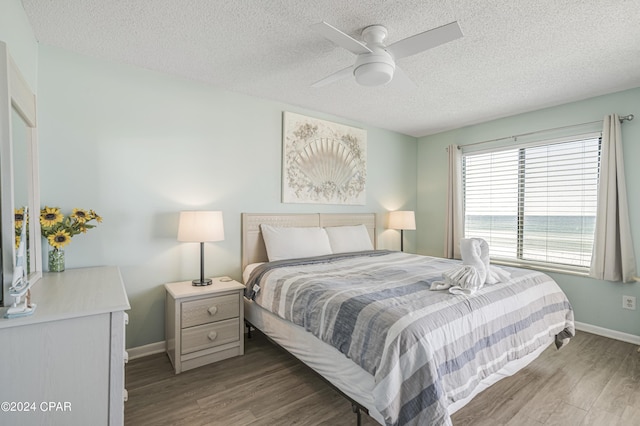 bedroom featuring hardwood / wood-style floors, ceiling fan, and a textured ceiling